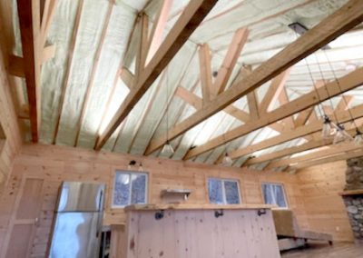 kitchen ceiling showing exposed beams and spray foam insulation